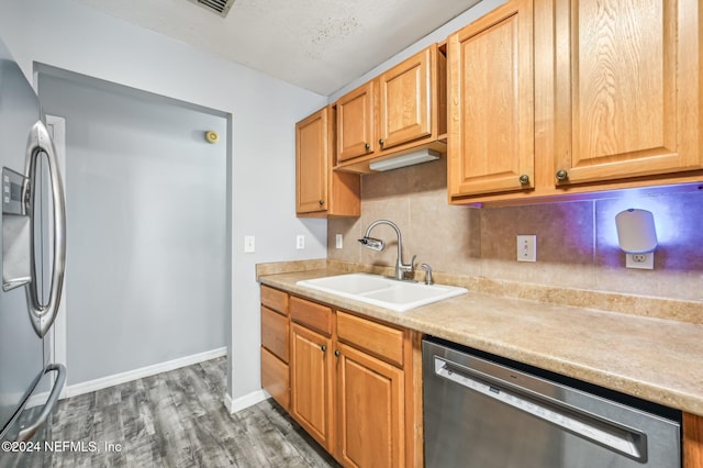 kitchen with stainless steel appliances, sink, dark hardwood / wood-style flooring, and decorative backsplash