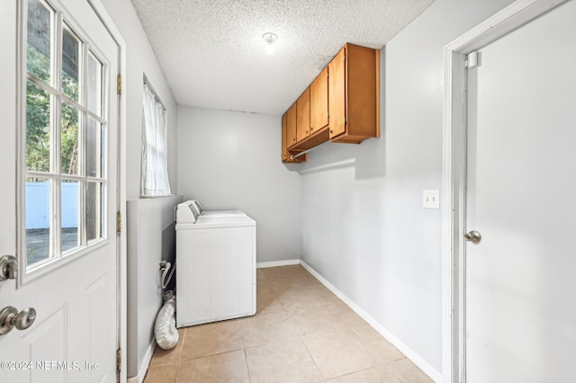 washroom featuring washer / clothes dryer, light tile patterned floors, a textured ceiling, and cabinets