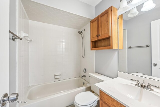 full bathroom featuring vanity, tiled shower / bath, and toilet