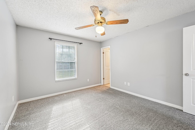 carpeted empty room featuring ceiling fan and a textured ceiling