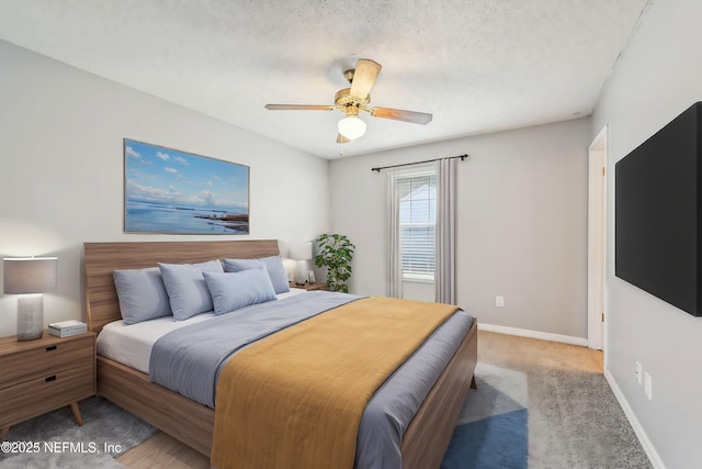 bedroom featuring ceiling fan, carpet, and a textured ceiling