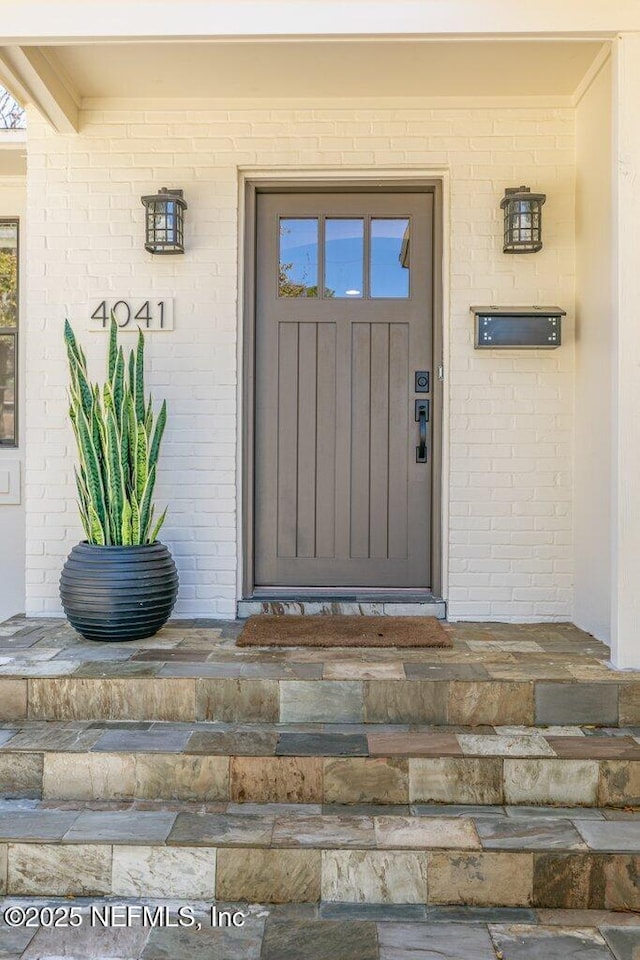 entrance to property featuring brick siding