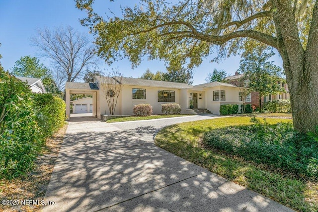 ranch-style house featuring driveway and stucco siding