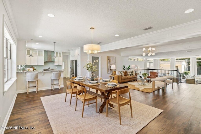 dining area with a textured ceiling, a notable chandelier, baseboards, ornamental molding, and dark wood-style floors