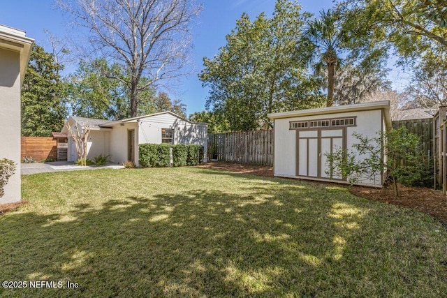 view of yard with a storage shed, a fenced backyard, and an outdoor structure