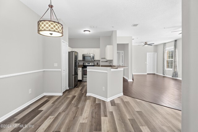 8601 Beach Blvd Unit 1007, Jacksonville, FL 32216 - kitchen featuring stainless steel appliances, open floor plan, white cabinetry, a ceiling fan, and dark wood-style floors