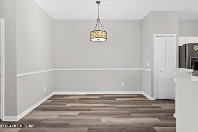 unfurnished dining area featuring dark wood-type flooring