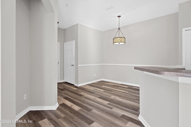 unfurnished dining area featuring dark wood-type flooring