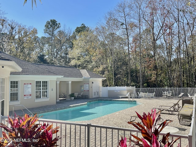 community pool featuring a patio and fence