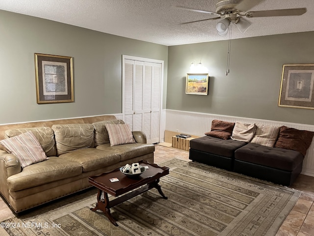 living room with ceiling fan and a textured ceiling