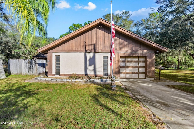 view of front of house with a front yard, a garage, and an outdoor structure