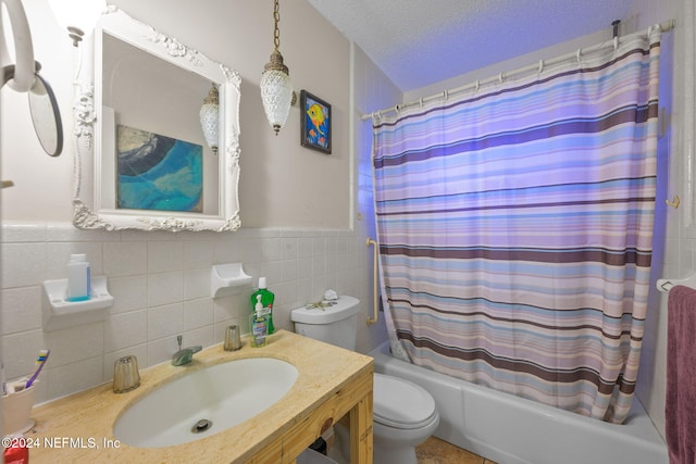 full bathroom featuring a textured ceiling, sink, shower / bath combo, and tile walls