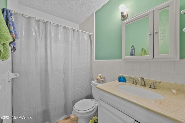 bathroom featuring a textured ceiling, vanity, tile walls, and toilet