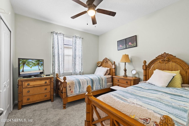 carpeted bedroom with a textured ceiling, a closet, and ceiling fan