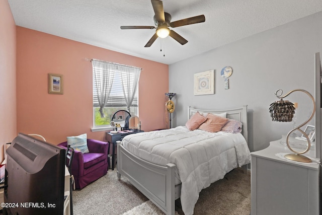 carpeted bedroom with ceiling fan and a textured ceiling