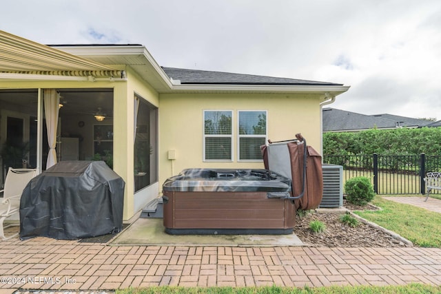 view of patio / terrace with cooling unit, grilling area, and a hot tub