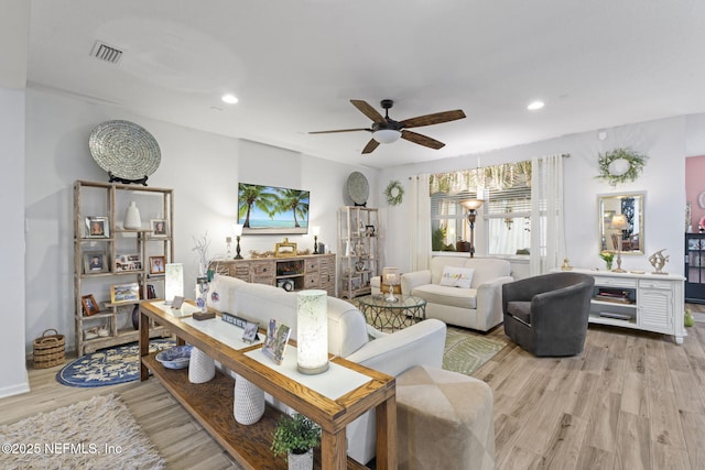 living room with ceiling fan and light hardwood / wood-style flooring