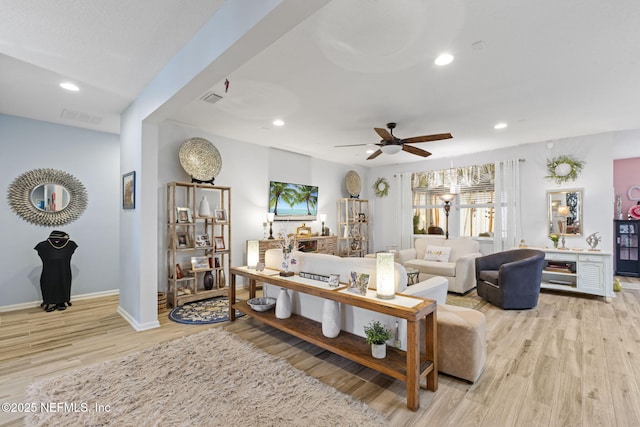 living room with light hardwood / wood-style flooring and ceiling fan