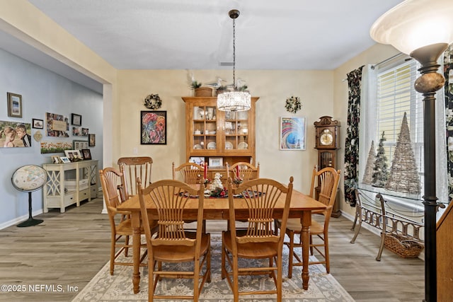 dining room with a chandelier and light hardwood / wood-style flooring