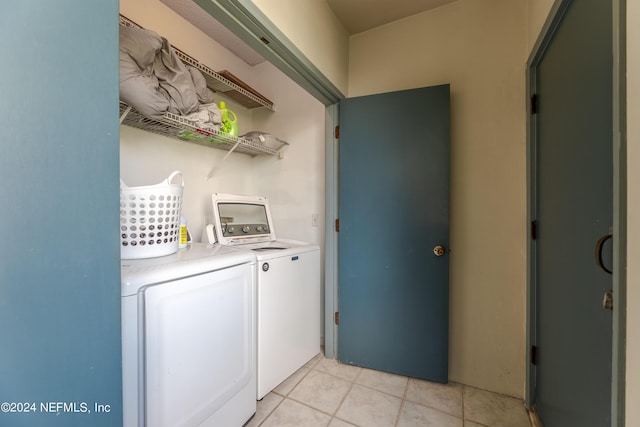 laundry room featuring washer and clothes dryer and light tile patterned flooring