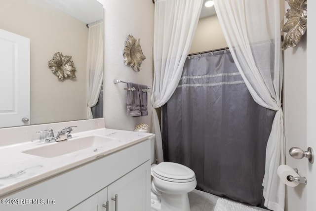 bathroom featuring tile patterned floors, vanity, and toilet