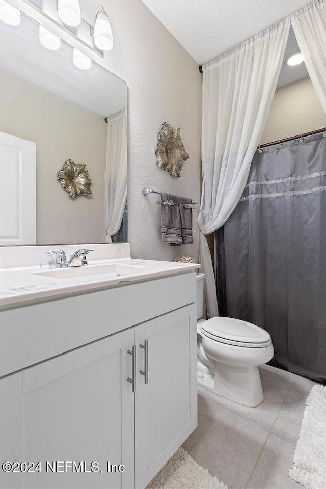 bathroom with tile patterned flooring, vanity, and toilet