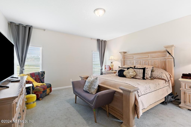 bedroom featuring light colored carpet and multiple windows