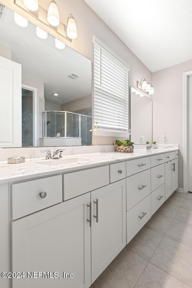 bathroom with tile patterned flooring, vanity, and an enclosed shower