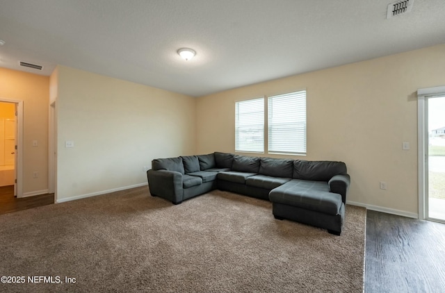 living area with a wealth of natural light, visible vents, and baseboards