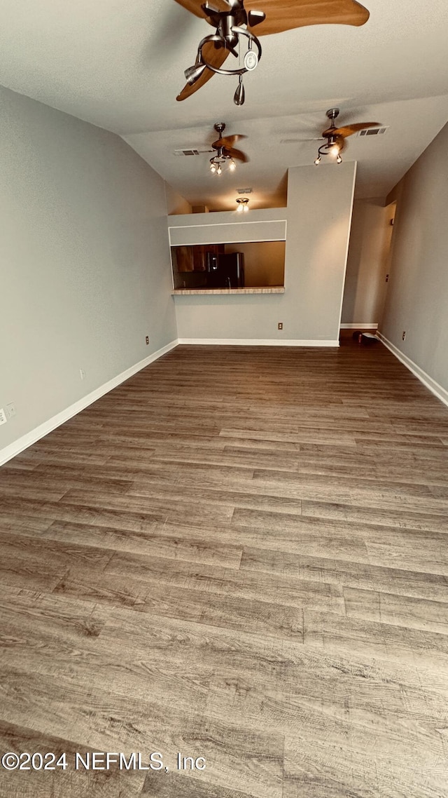 unfurnished living room featuring hardwood / wood-style flooring and lofted ceiling