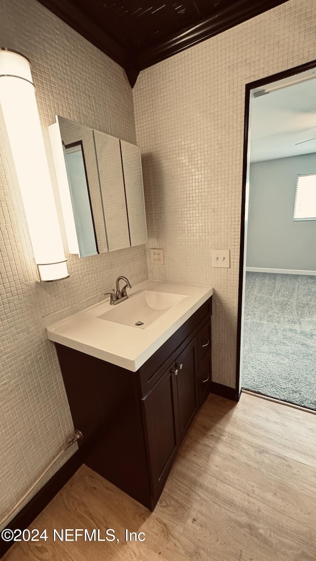 bathroom featuring vanity, hardwood / wood-style flooring, and tile walls