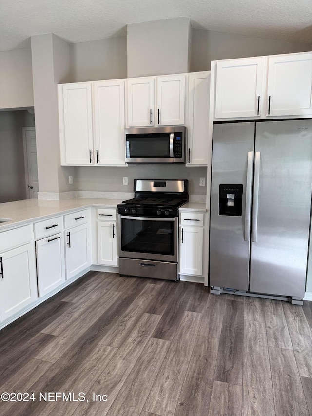 kitchen featuring a textured ceiling, dark hardwood / wood-style flooring, stainless steel appliances, and white cabinetry