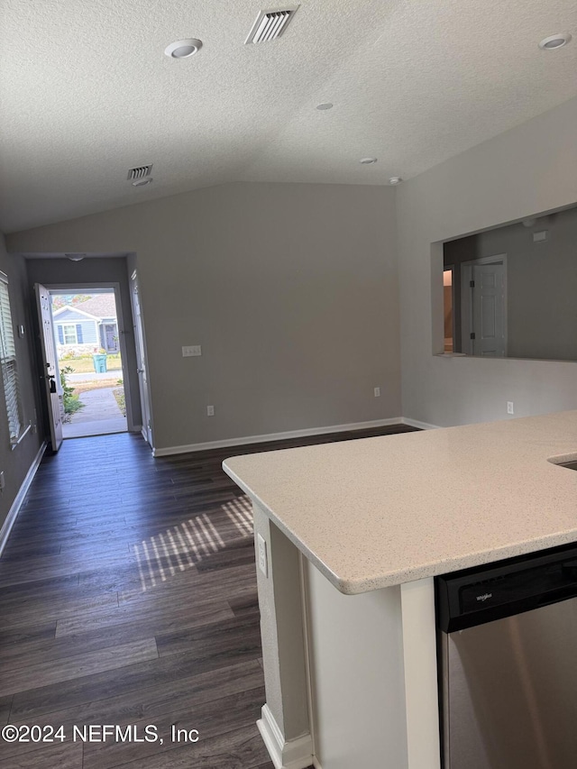 kitchen with kitchen peninsula, dark hardwood / wood-style flooring, stainless steel dishwasher, a textured ceiling, and lofted ceiling