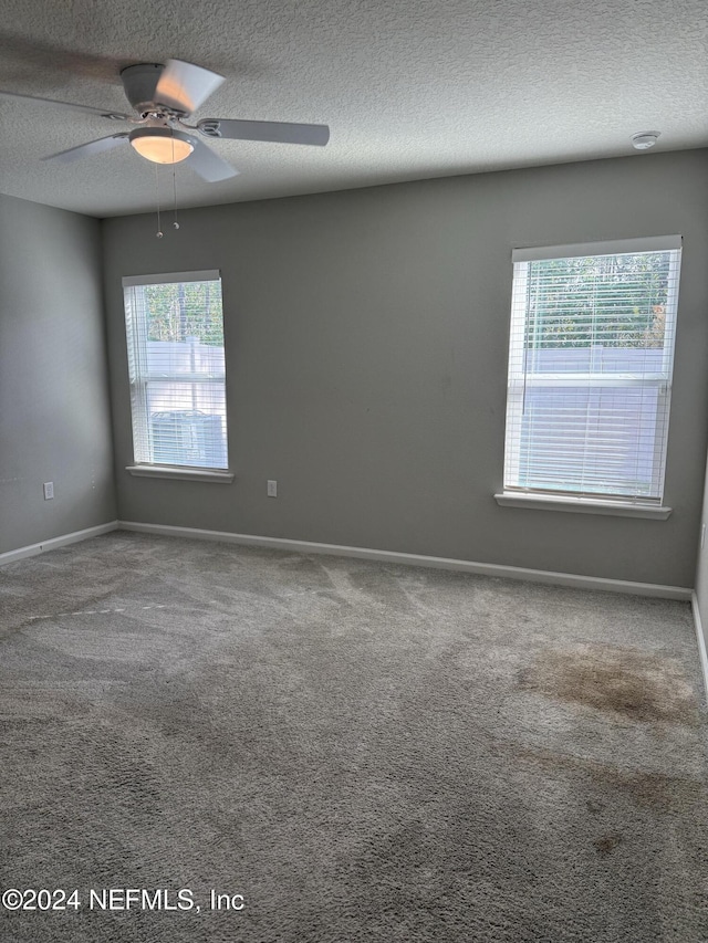 spare room with carpet flooring, ceiling fan, and a textured ceiling