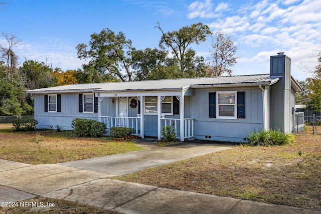 single story home featuring covered porch and a front yard