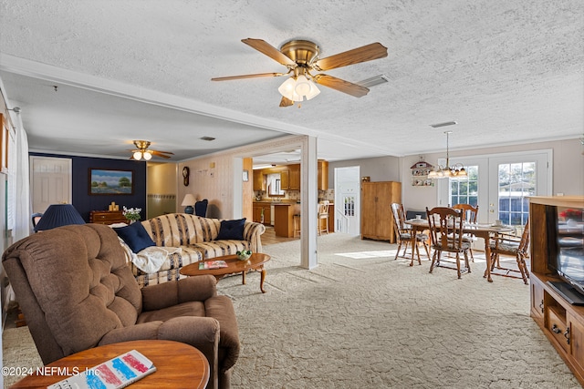 carpeted living room featuring french doors, a textured ceiling, ceiling fan, and ornamental molding