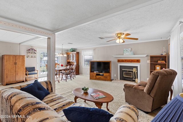 carpeted living room featuring ceiling fan with notable chandelier, crown molding, a textured ceiling, and a wealth of natural light