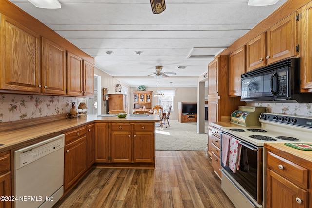 kitchen featuring wood counters, white appliances, dark wood-type flooring, ceiling fan, and kitchen peninsula