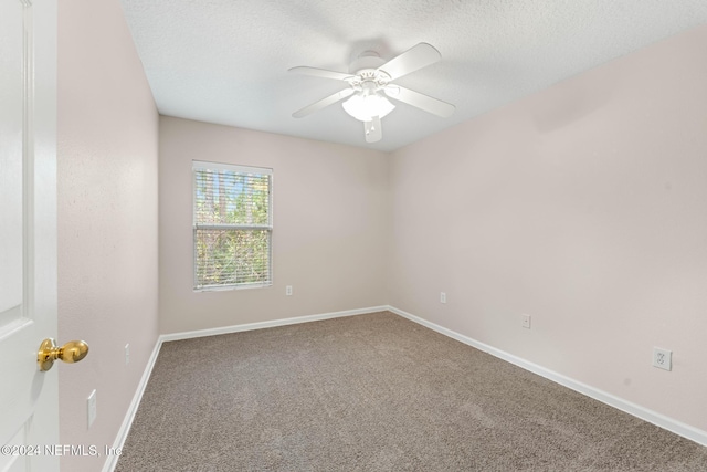 empty room with ceiling fan, carpet, and a textured ceiling