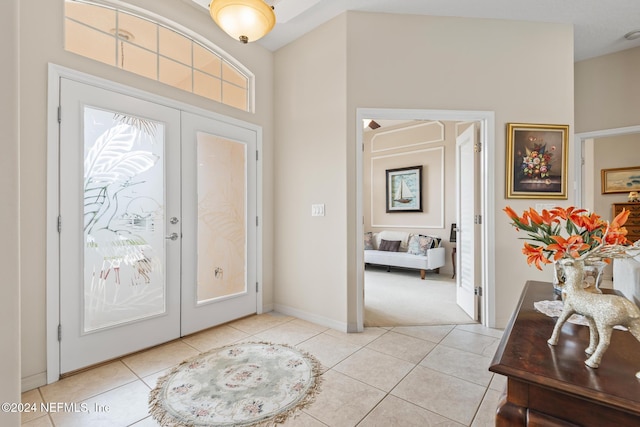 entryway with light tile patterned flooring, french doors, and baseboards