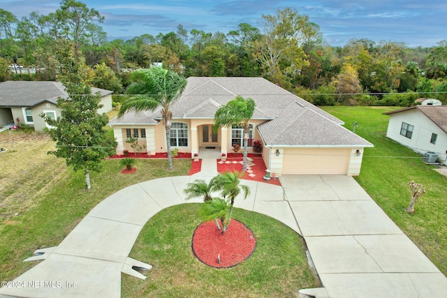 view of front of home with a front yard, roof with shingles, stucco siding, driveway, and an attached garage