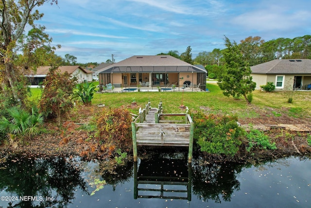 view of dock featuring glass enclosure, a yard, and an outdoor pool