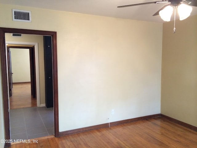 unfurnished room featuring ceiling fan and dark wood-type flooring