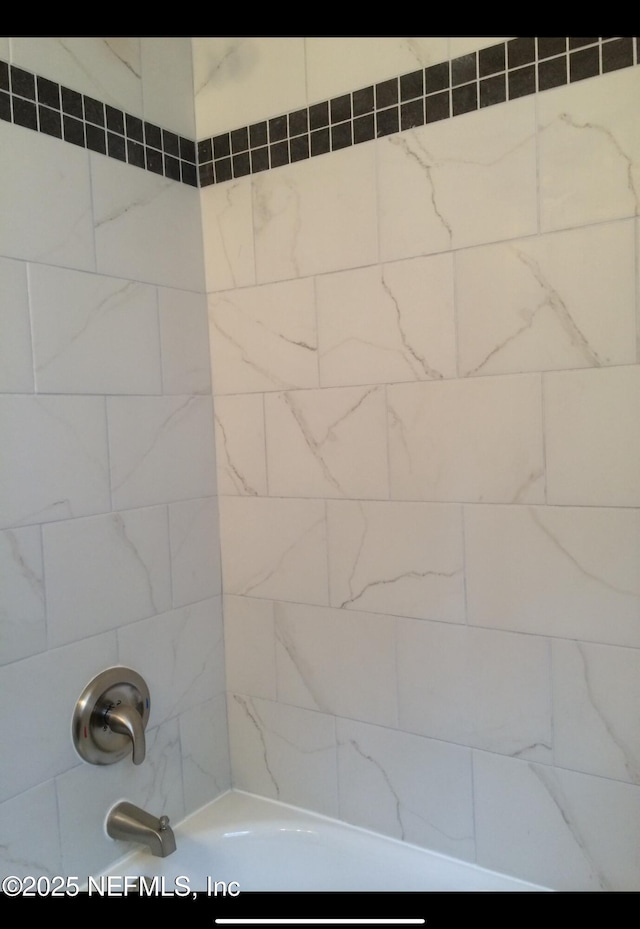 bathroom featuring tiled shower / bath