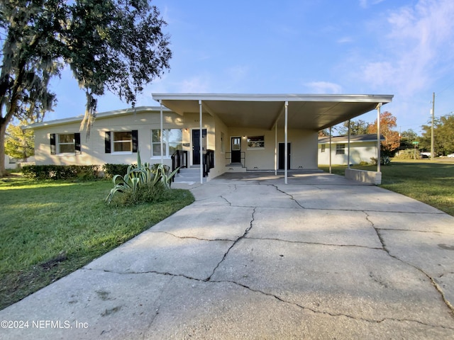 view of front of property with a carport and a front lawn