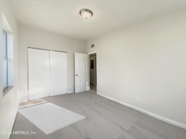 unfurnished bedroom featuring carpet flooring and a closet