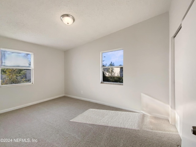 unfurnished bedroom with carpet, a textured ceiling, and a closet