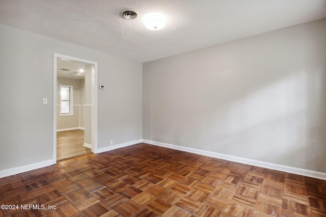 unfurnished room featuring dark parquet flooring