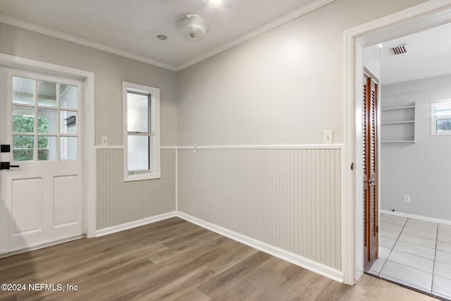 entryway with hardwood / wood-style flooring and crown molding