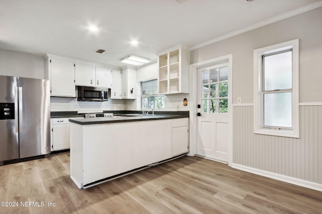 kitchen with white cabinets, crown molding, appliances with stainless steel finishes, and light hardwood / wood-style flooring